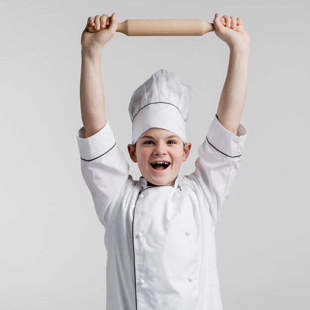 Portrait, de, heureux, jeune garçon, tenue, rouleau à pâtisserie