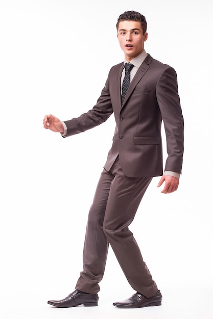 Portrait d'heureux jeune homme d'affaires souriant en costume marron isolé sur mur blanc