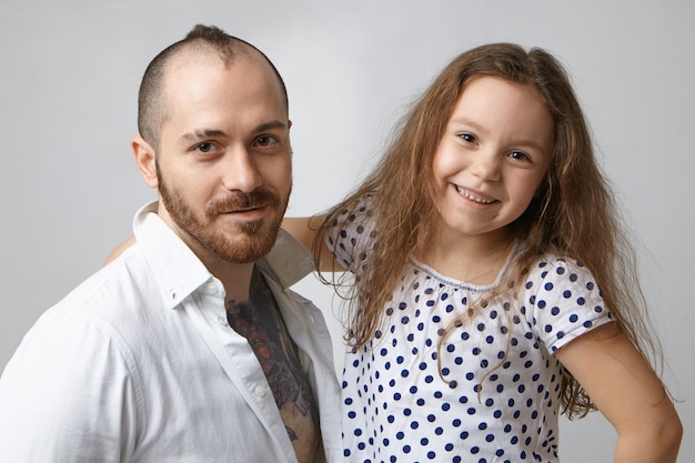 Photo gratuite portrait d'heureux jeune père moderne et élégant avec barbe et coiffure créative posant en studio
