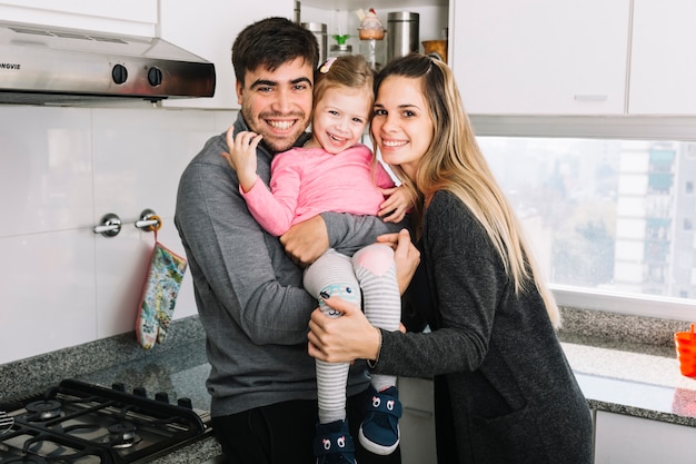 Portrait d&#39;un heureux parents avec leur fille dans la cuisine