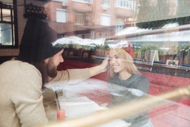 Portrait de hipsters au café derrière la vitre