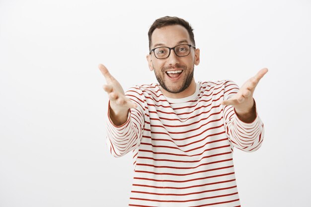 Portrait d'un homme adulte heureux surpris voyant un ami et tirant les mains vers