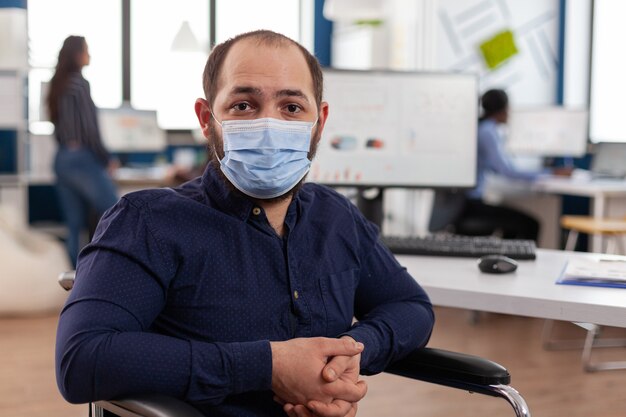 Portrait d'un homme d'affaires handicapé portant un masque de protection médicale