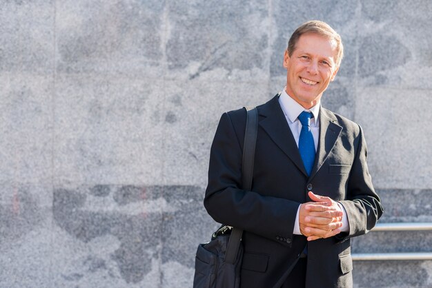 Portrait d&#39;un homme d&#39;affaires mature heureux avec les mains jointes