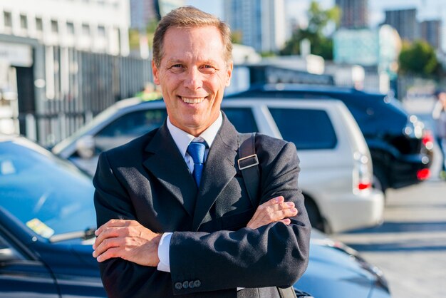 Portrait d&#39;un homme d&#39;affaires mature souriant avec les bras croisés