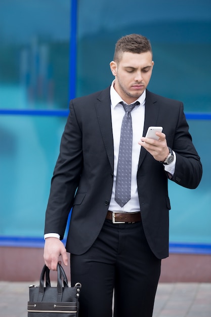 Portrait d&#39;homme d&#39;affaires regardant l&#39;écran des smartphones avec une expression ciblée