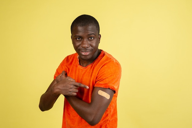 Portrait d'un homme africain isolé sur un mur de studio jaune