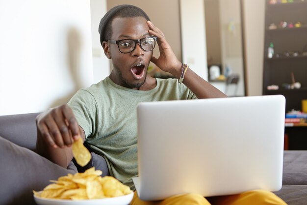 Portrait d'un homme afro-américain élégant avec un ordinateur portable à la maison