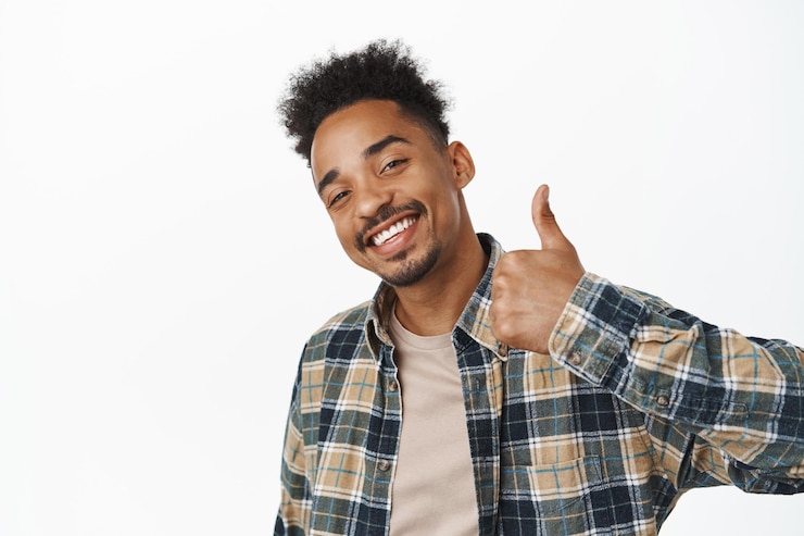 Photo gratuit portrait d'un homme afro-américain heureux souriant satisfait, dites oui, montrant le pouce vers le haut en signe d'approbation, encouragez-vous à faire du bon travail, louez un bon choix, fond blanc