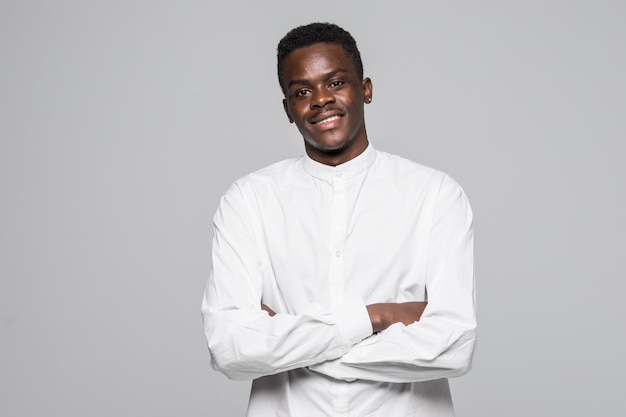 Portrait d'un homme afro confiant vêtu d'une chemise classique blanche avec les mains jointes isolé sur fond gris