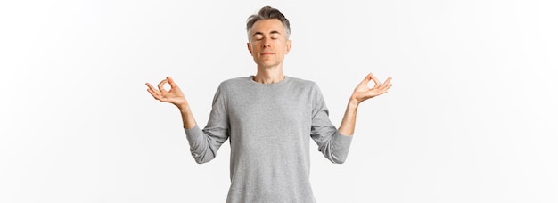 Photo gratuite portrait d'un homme d'âge moyen calme et détendu respirant l'air librement méditant avec les yeux fermés et han