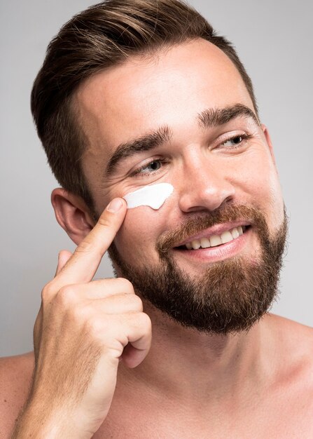 Portrait d'homme à l'aide de crème pour le visage