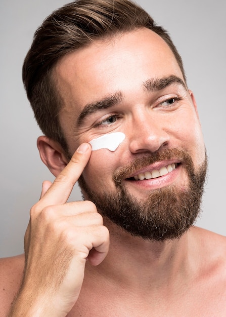 Portrait d'homme à l'aide de crème pour le visage