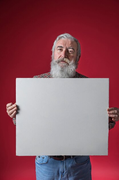 Portrait, de, a, homme aîné, projection, vierge, blanc, plaque, debout, contre, toile de fond rouge
