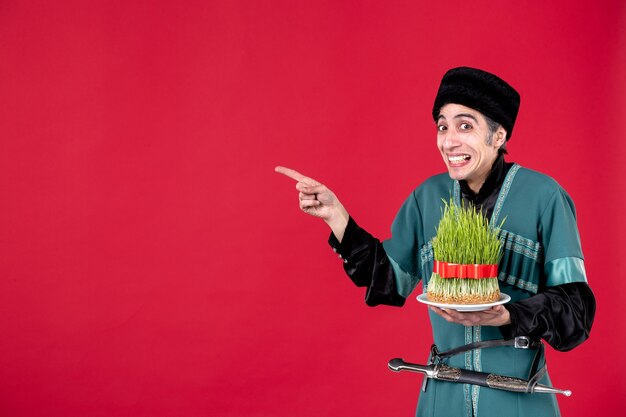 Portrait d'un homme azéri en costume traditionnel avec semeni sur danseur de vacances ethnique novruz rouge