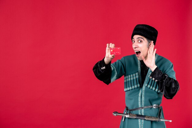 Portrait d'un homme azéri en costume traditionnel tenant une carte de crédit studio shot red novruz printemps argent