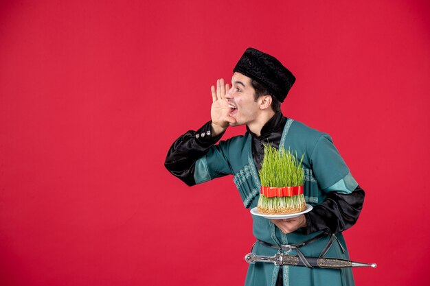 Portrait d'homme azéri en costume traditionnel tenant semeni studio shot rouge