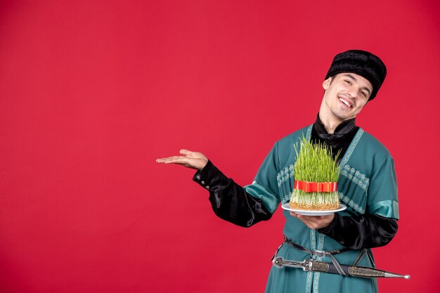 Portrait d'un homme azéri en costume traditionnel tenant un studio de semeni danseur de novruz concept rouge