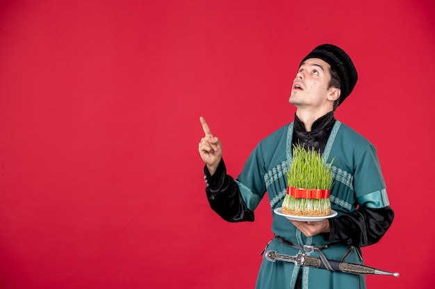 Portrait d'un homme azéri en costume traditionnel tenant un studio semeni tourné concept rouge interprète de novruz