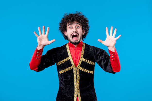 Photo gratuite portrait d'un homme azéri excité en costume traditionnel tourné en studio fond bleu concept de printemps ethnique danseuse novruz