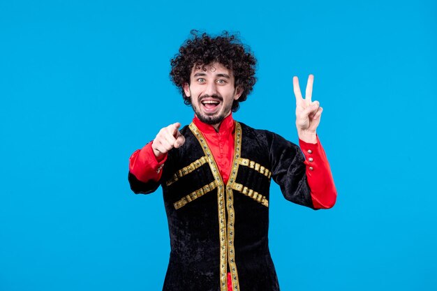 Portrait d'un homme azéri posant en costume traditionnel tourné en studio fond bleu concept ethnique novruz printemps