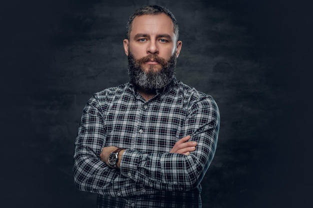 Photo gratuite portrait d'un homme barbu d'âge moyen sérieux vêtu d'une chemise en flanelle à carreaux sur fond gris.