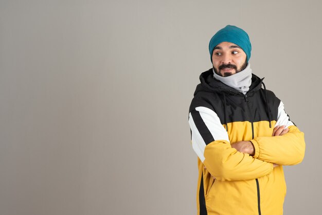 Portrait d'homme barbu dans des vêtements chauds debout avec les bras croisés.