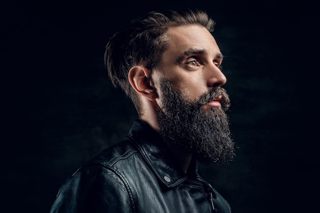 Portrait d'homme barbu désespéré avec coiffure sur fond noir.