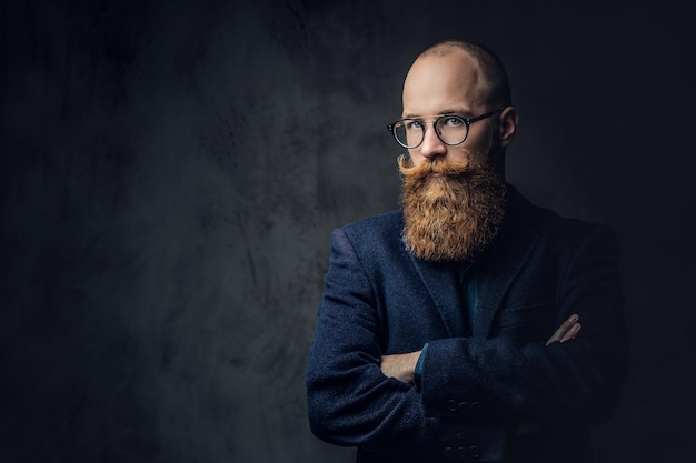 Photo gratuite portrait d'homme barbu rousse à lunettes vêtu d'un élégant costume de laine sur fond gris.