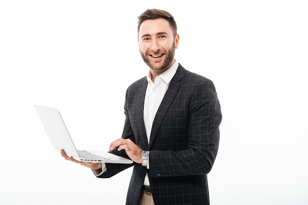 Portrait d'un homme barbu souriant tenant un ordinateur portable