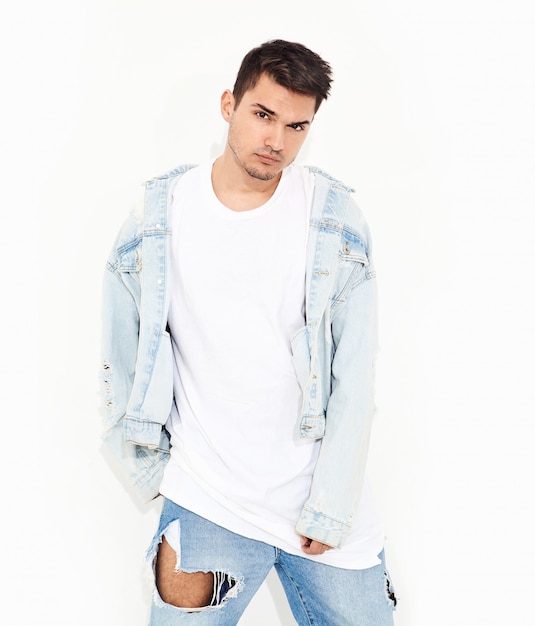 Portrait d'un homme beau jeune mannequin vêtu de vêtements jeans posant. Isolé