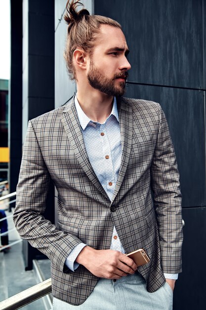 Portrait d'un homme beau sexy vêtu d'un élégant costume à carreaux beige