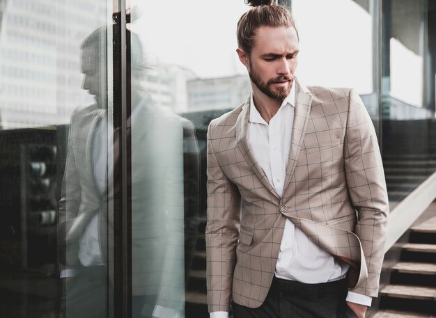 Portrait d'un homme beau sexy vêtu d'un élégant costume à carreaux beige