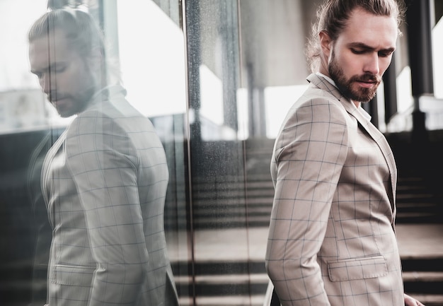 Photo gratuite portrait d'un homme beau sexy vêtu d'un élégant costume à carreaux beige