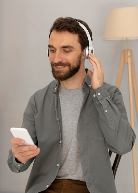 Portrait homme avec un casque d'écoute de la musique sur mobile