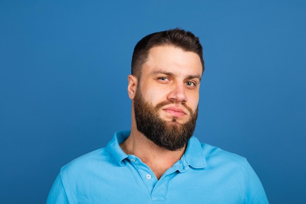 Portrait d'homme caucasien isolé sur fond de studio bleu avec fond