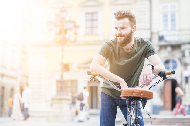 Photo gratuite portrait, de, a, homme, cycliste, vélo, regarder loin