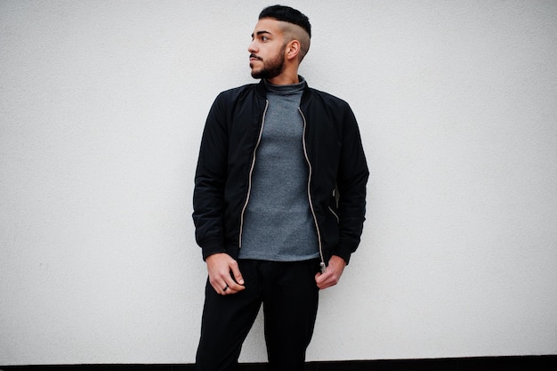 Photo gratuite portrait d'un homme élégant à la barbe arabe portant un col roulé gris et un jaket noir