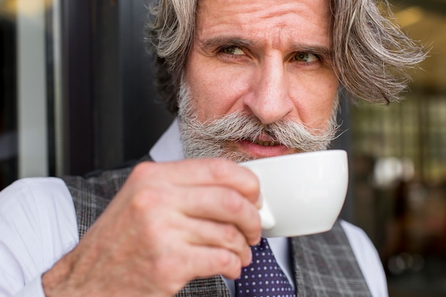 Portrait d'homme élégant bénéficiant d'une tasse de café
