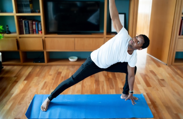 Portrait d'un homme faisant de l'exercice tout en restant à la maison. Nouveau concept de mode de vie normal. Notion de sport.