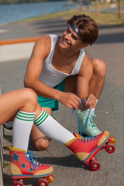 Portrait d'homme et de femme à la plage avec des patins à roulettes dans l'esthétique des années 80