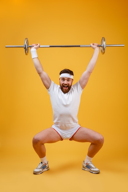 Portrait d'un homme de fitness accroupi avec haltères