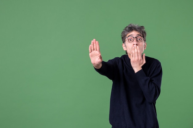 Portrait D'un Homme De Génie En Studio Demandant De S'arrêter Sur La Couleur De L'école Masculine Horizontale De Surface Verte