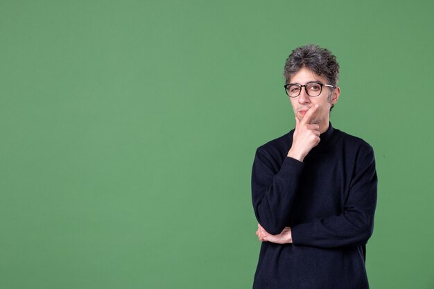 Portrait d'un homme de génie en studio, pensant sur une surface verte, couleur horizontale, étudiant enseignant humain masculin