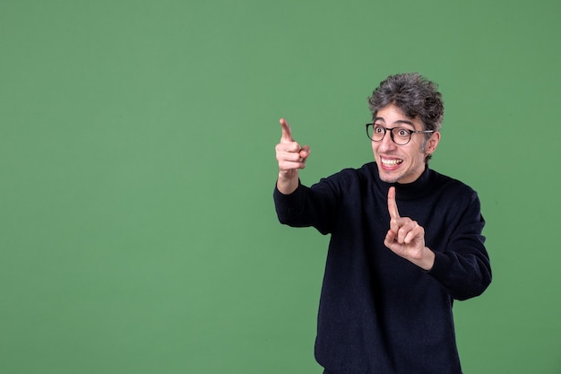 Portrait d'homme de génie en studio tourné sur mur vert