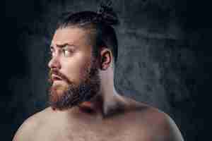 Photo gratuite portrait d'un homme gras et barbu torse nu sur fond gris.