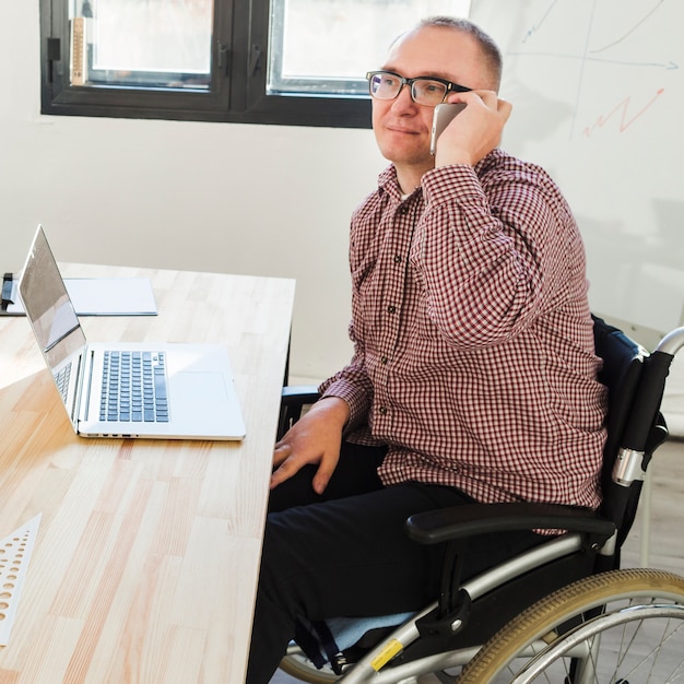 Portrait d'un homme handicapé travaillant au bureau