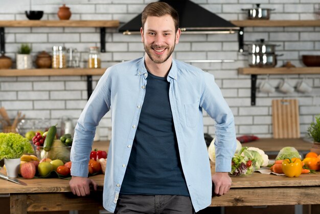 Portrait d'un homme heureux, debout dans la cuisine
