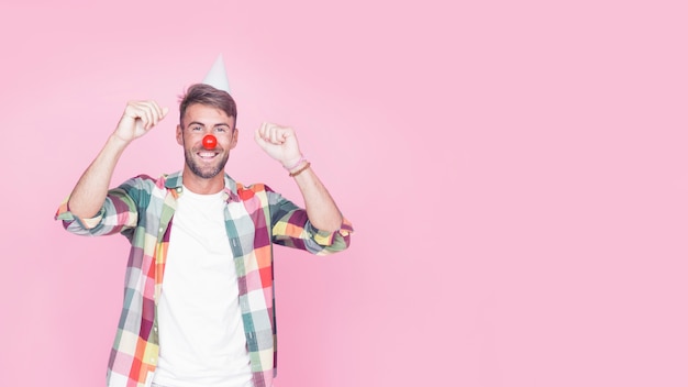 Portrait d&#39;un homme heureux avec nez de clown sur fond rose