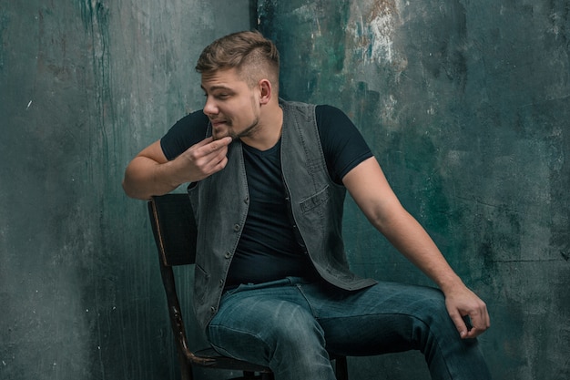 Portrait d'homme heureux souriant assis sur la chaise en studio